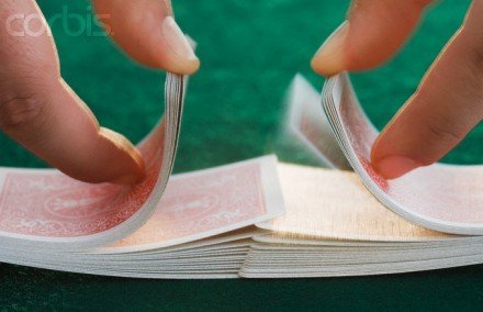 Shuffling cards on poker table - Image by Corbis